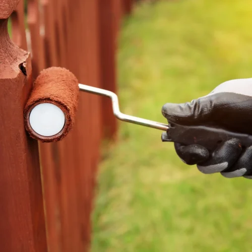 Person-painting-fence-with-roller-scaled.jpg